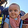 baby, child, stroller, bib, outdoor, sunlight, grass, man, woman, sunglasses, cap, smile, portrait, people, casual_clothing, happy, daylight, family, park, baby_bib