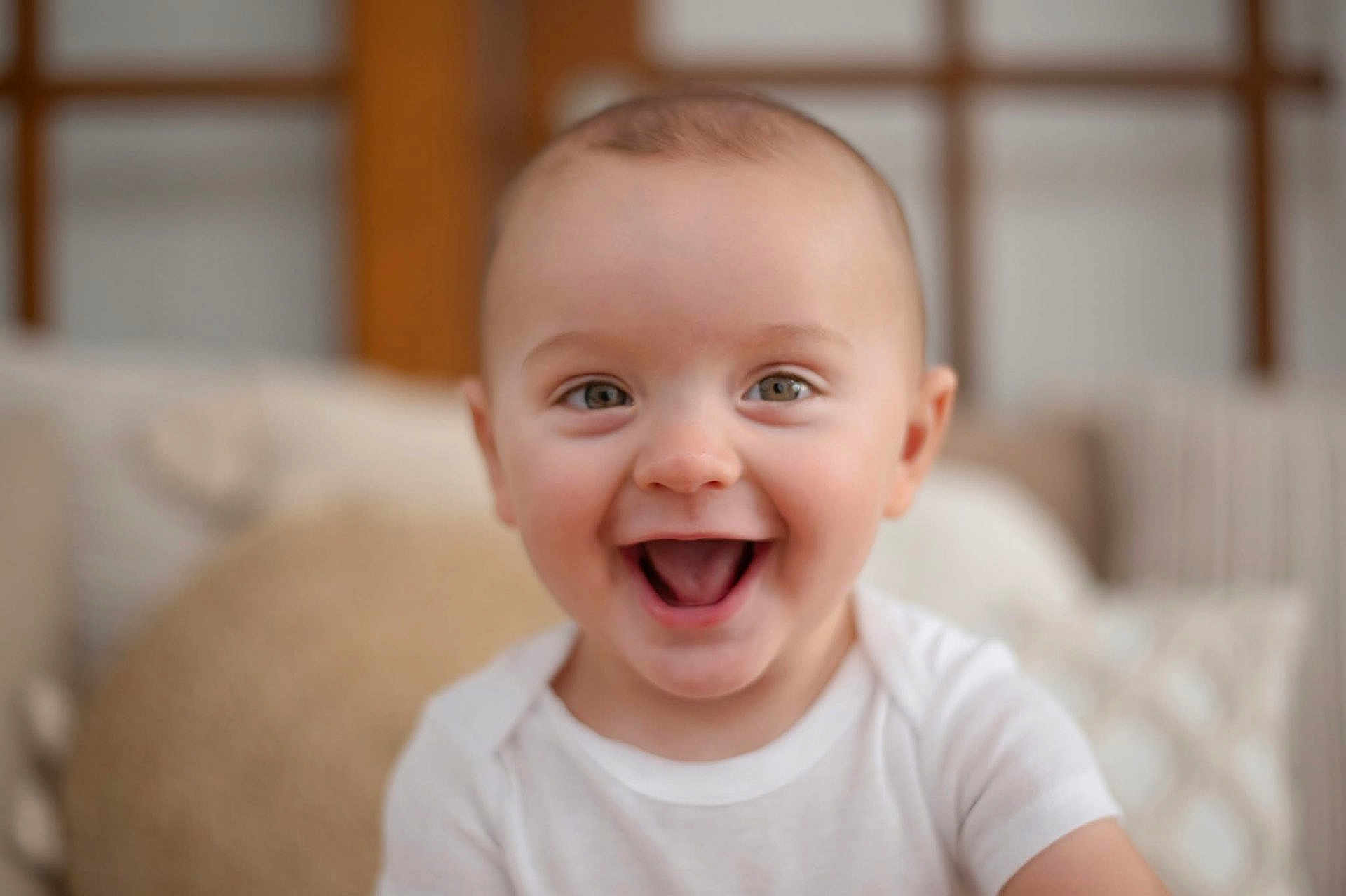 Dalton is registered to the contest to win money with this photo: baby, smiling, happy, face, infant, child, white_shirt, indoors, portrait, cute, head, eyes, mouth, skin, person, young, expression, closeup, background_blur, soft_light