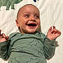 Dalton is registered to the contest to win money with this photo: baby, child, smile, dinosaur, onesie, blanket, happy, infant, cute, clothing, lying_down, face, portrait, indoor, person, small_hands, joyful, skin, head, expression