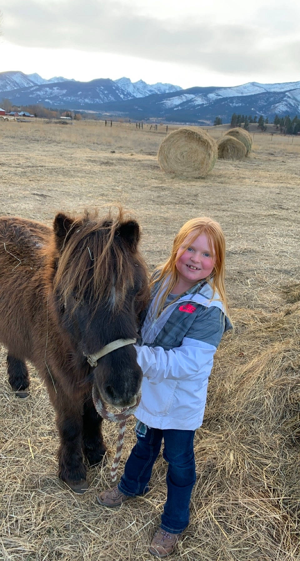 Brooke is registered to the contest to win money with this photo: ecoregion, fun, grass, grassland, horse, horse_supplies, joy, landscape, livestock, mane, mountain, pack_animal, people_in_nature, person, ranch, shetland_pony, sky, smile, sporting_group, toddler
