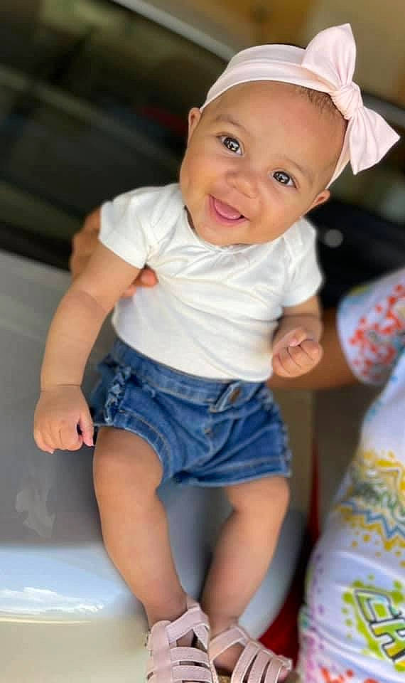 Lenox is registered to the contest to win money with this photo: baby, baby_toddler_clothing, child, eye, face, facial_expression, hairstyle, hand, happy, head, joy, people, person, pink, shorts, skin, sleeve, smile, standing, t_shirt