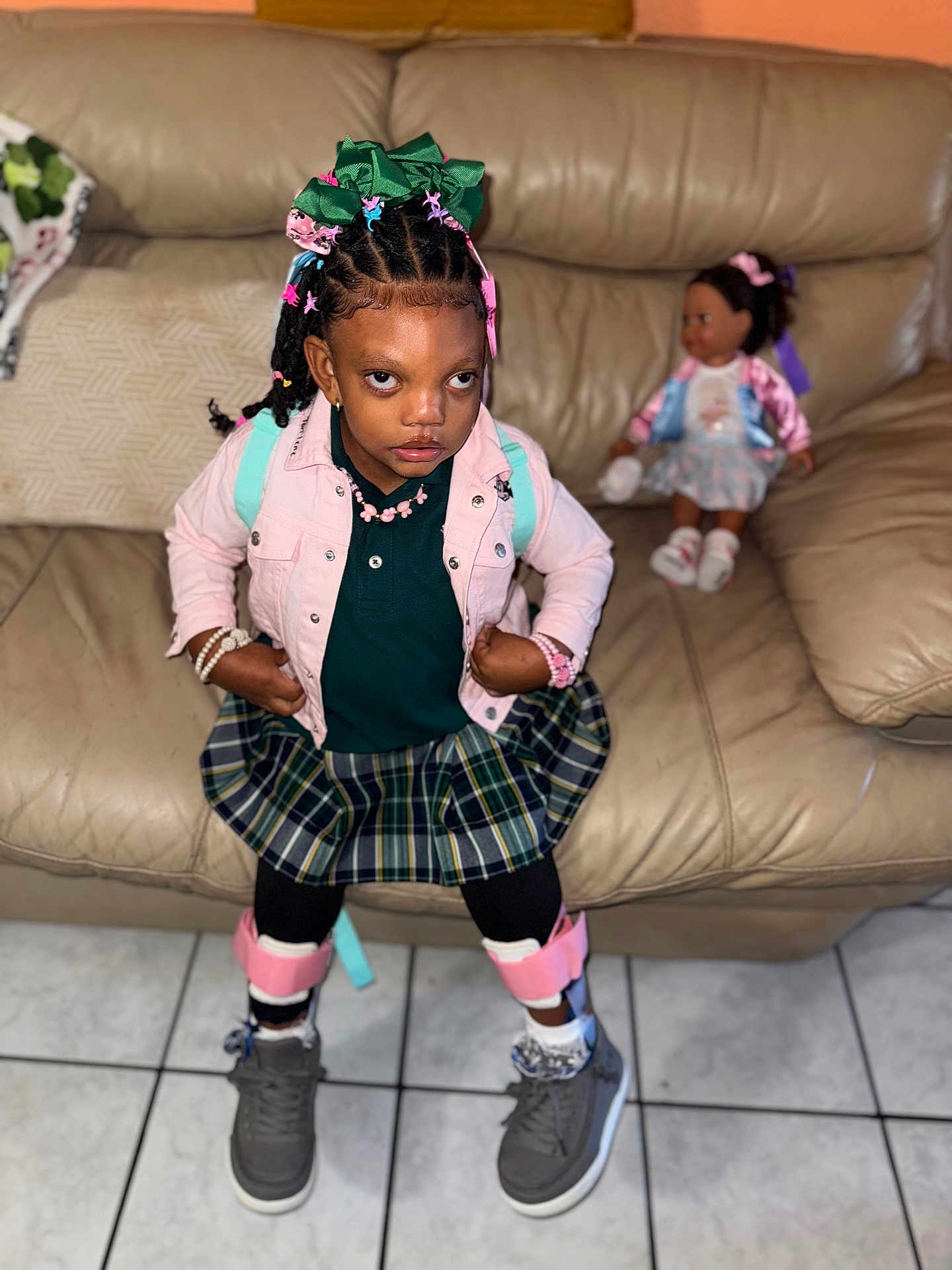 Tonlene Godqueen joined the competition — help win amazing prizes! child, girl, plaid_skirt, pink_jacket, hair_bows, bracelets, doll, leather_couch, tile_floor, sneakers, black_tights, indoor, person, portrait, fashion, accessories, confident, toy, home, seated_doll