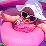 Isla Jean is registered to the contest to win money with this photo: baby, infant, child, sunglasses, sun_hat, pink_float, swimming_pool, poolside, outdoor, summer, vacation, smiling, portrait, sitting, water, sunlight, pink_clothing, floral_details, playful, fashionable