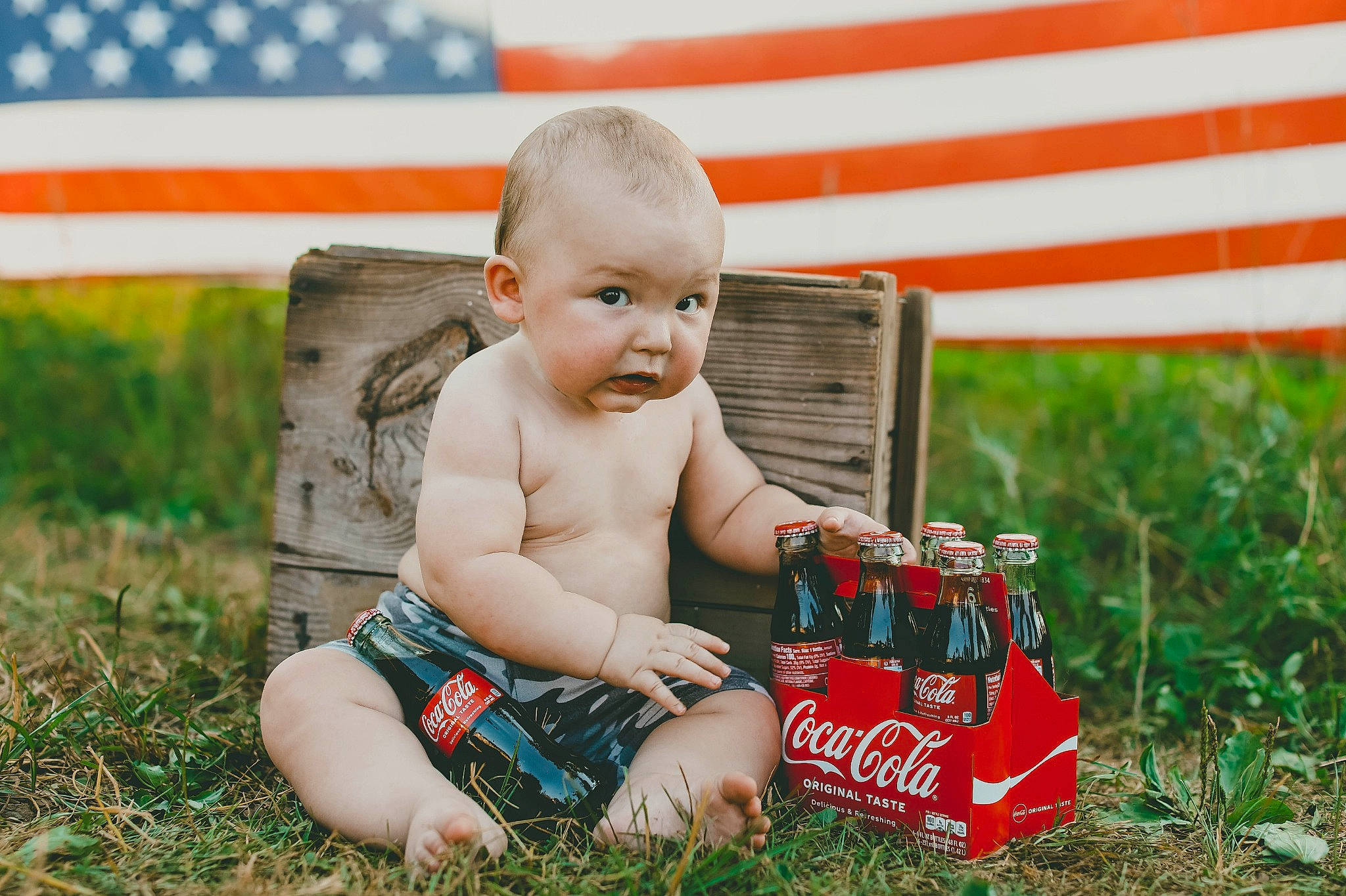Waylen is registered to the contest to win money with this photo: baby, carbonated_soft_drinks, child, drink, fun, grass, grass_family, grassland, happy, holiday, human_leg, lawn, leisure, people_in_nature, person, plant, play, recreation, sitting, toddler