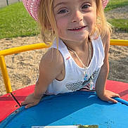 Séréna a rejoint le concours — aidez-le/la à gagner de superbes lots ! blue_surface, casual_clothing, child, daylight, girl, grass, happy, keys, map, necklace, outdoor, park, pink_hat, playground, playing, smiling, sunny, white_tank_top, yellow_rail, young