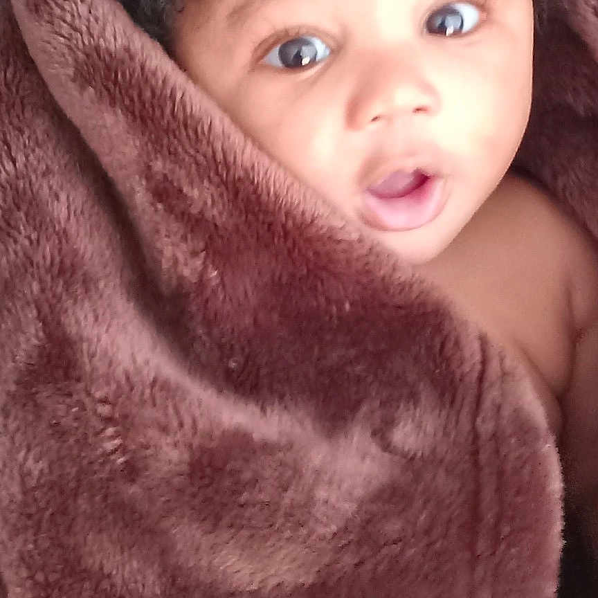 Kashston joined the competition — help win amazing prizes! baby, blanket, brown, child, closeup, cozy, curly_hair, cute, expression, face, indoor, infant, person, portrait, skin, soft_texture, surprised, warm, wrapped, young