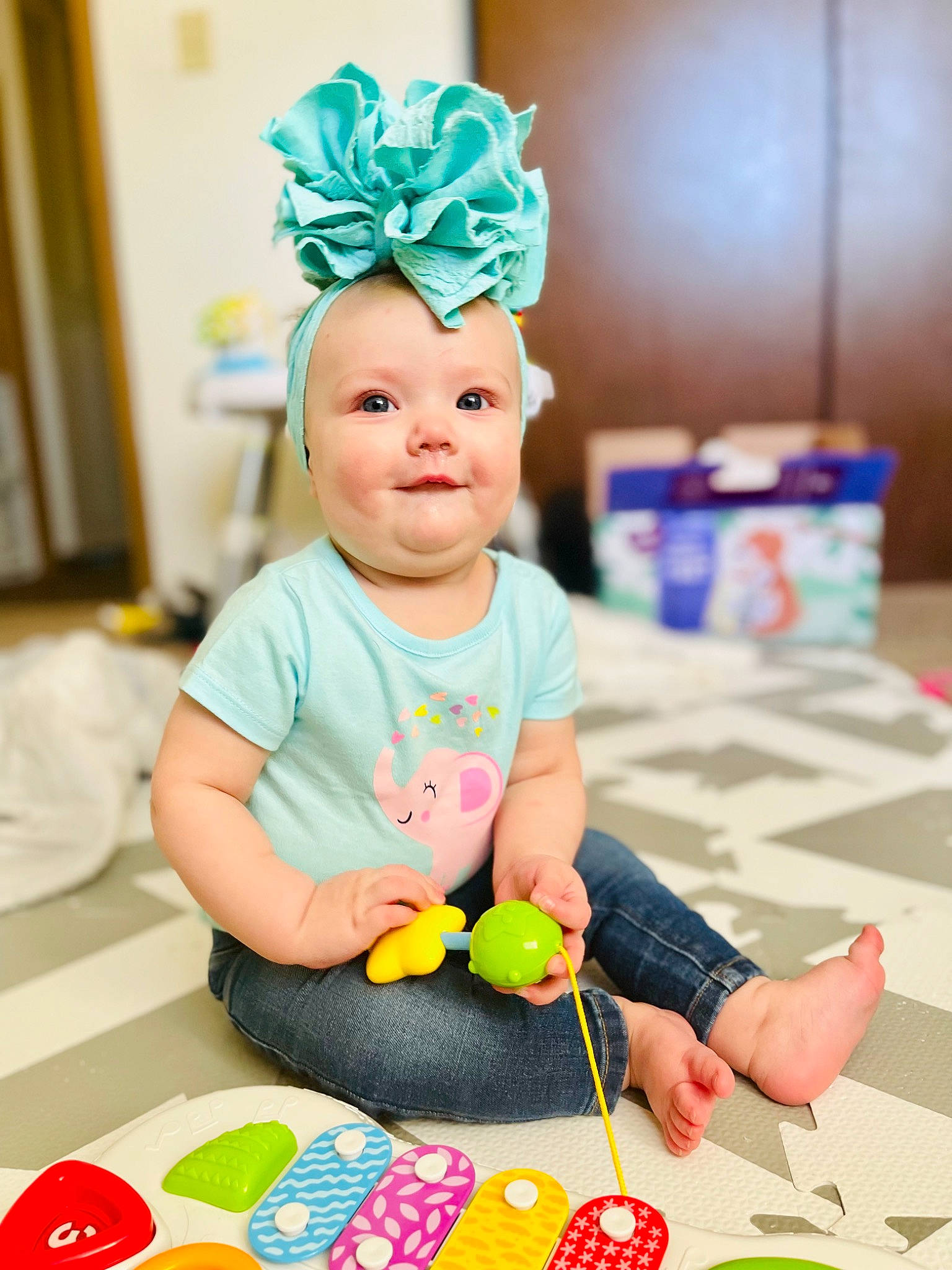 Isabella is registered to the contest to win money with this photo: baby, baby_playing_with_toys, blue, cap, child, event, finger, fun, green, happy, headpiece, joy, leisure, party_supply, person, personal_protective_equipment, photograph, play, purple, snapshot