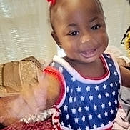 Cheyenne joined the competition — help win amazing prizes! child, toddler, girl, smiling, waving, portrait, indoor, home, couch, blanket, hair_bows, dress, stars, red_white_blue, happy, face, eyes, sitting, close_up, family_photo
