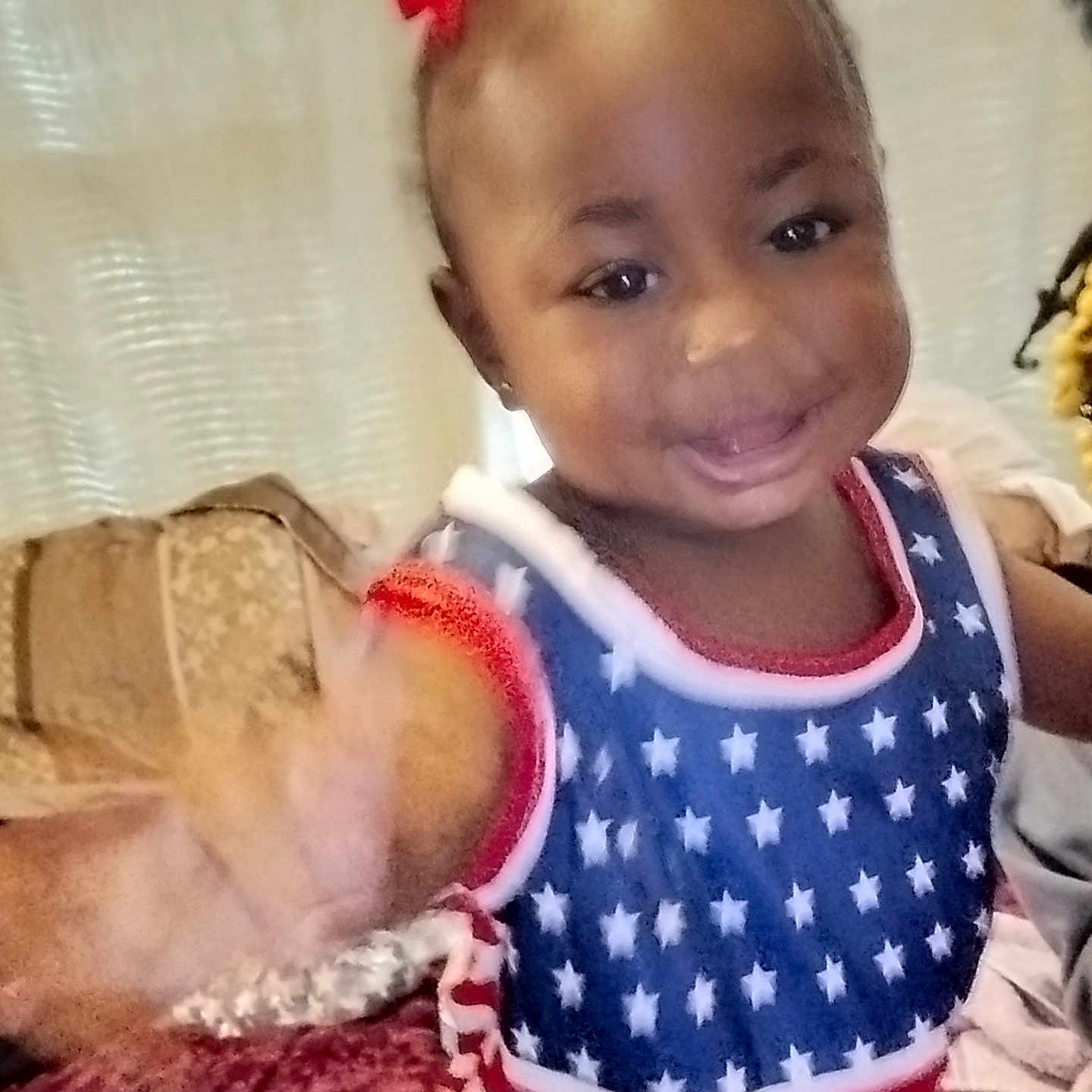 Cheyenne joined the competition — help win amazing prizes! child, toddler, girl, smiling, waving, portrait, indoor, home, couch, blanket, hair_bows, dress, stars, red_white_blue, happy, face, eyes, sitting, close_up, family_photo