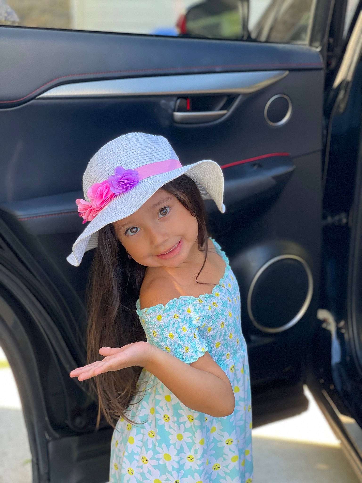 Ariana is registered to the contest to win money with this photo: auto_part, automotive_design, automotive_exterior, automotive_lighting, automotive_tire, bumper, dress, electric_blue, fun, happy, hat, headgear, headwear, joy, mammal, motor_vehicle, person, skin, smile, standing