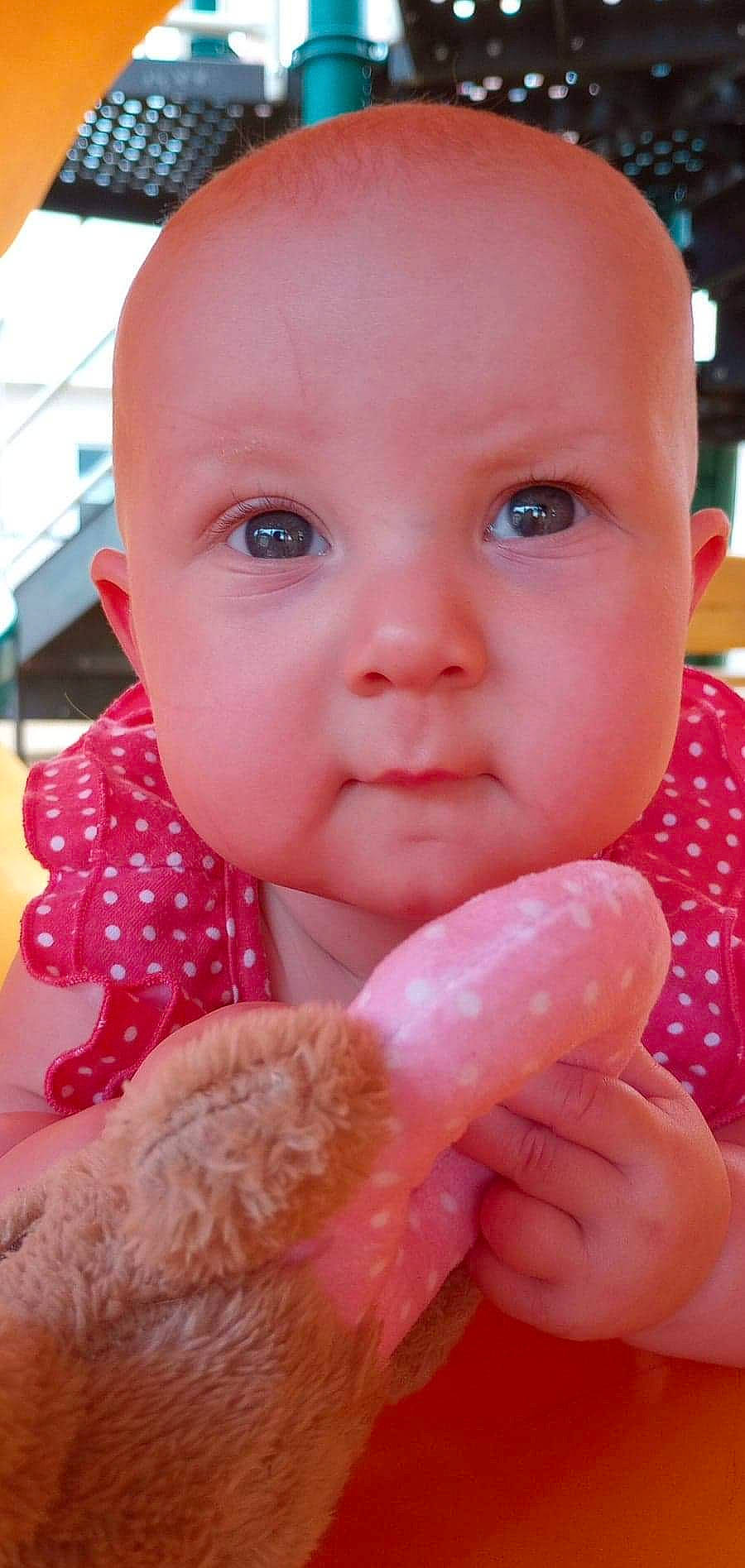 Gabriella is registered to the contest to win money with this photo: baby, baby_toddler_clothing, cheek, chin, finger, gesture, hand, happy, iris, lip, mouth, nail, nose, organ, people, person, pink, product, skin, thumb