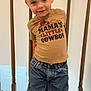 Pave is registered to the contest to win money with this photo: child, boy, smiling, tshirt, jeans, standing, indoors, wooden_railing, carpet, casual_clothing, cute, portrait, happy, fashion, person, young_child, hair, denim, footwear, home