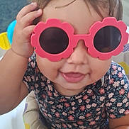 Alani joined the competition — help win amazing prizes! baby, child, sunglasses, pink, flower_shape, smiling, playing, activity_center, toy, hand, face, cute, indoor, person, clothing, short_sleeve, hair, expression, fun, happy