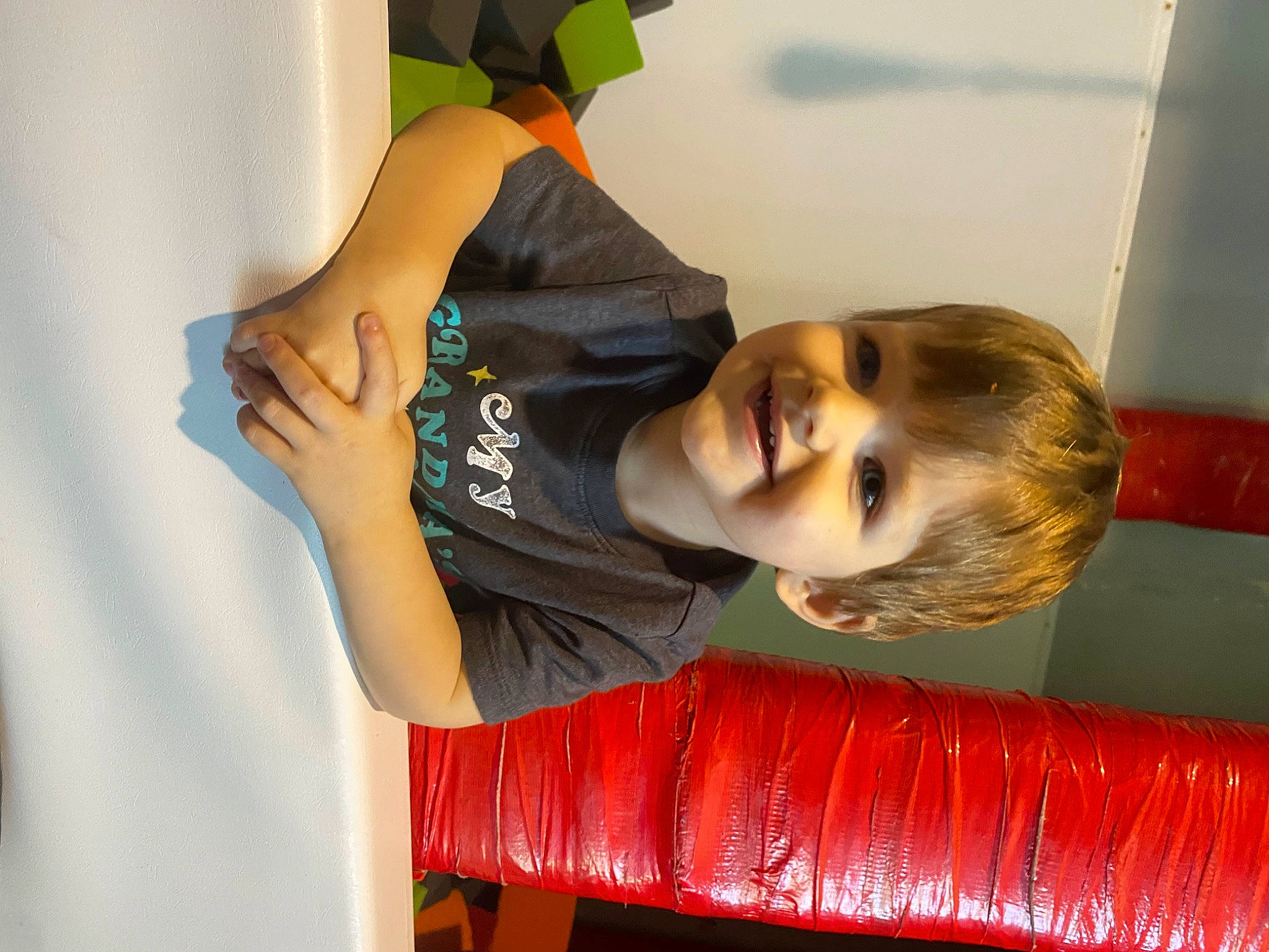 Leon is registered to the contest to win money with this photo: arm, child, comfort, elbow, fun, gesture, happy, joy, leisure, orange, person, room, sleeve, smile, t_shirt, toddler, wrist