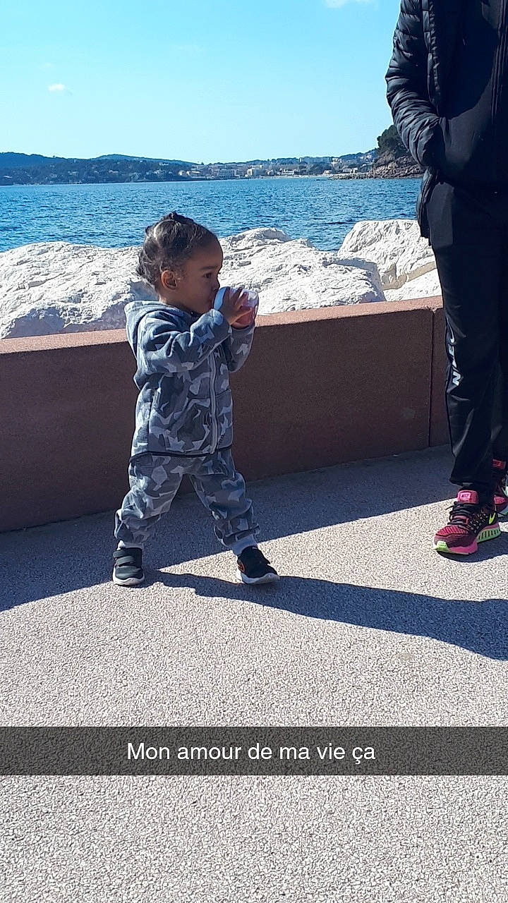 Jayan a rejoint le concours — aidez-le/la à gagner de superbes lots ! asphalt, blue, child, electric_blue, fun, gesture, horizon, human_leg, lake, leg, leisure, people_in_nature, person, recreation, shoe, sitting, sky, sneakers, toddler, travel