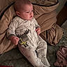 baby, infant, child, portrait, bed, bedding, blanket, clothing, onesie, moose, animal_print, lying_down, indoors, bedroom, cozy, face, hair, hands, feet, photograph