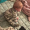 baby, child, infant, camouflage, pajamas, kneeling, sitting, bed, bedding, quilt, blanket, cozy, portrait, profile, face, indoor, home, hands, feet, cute