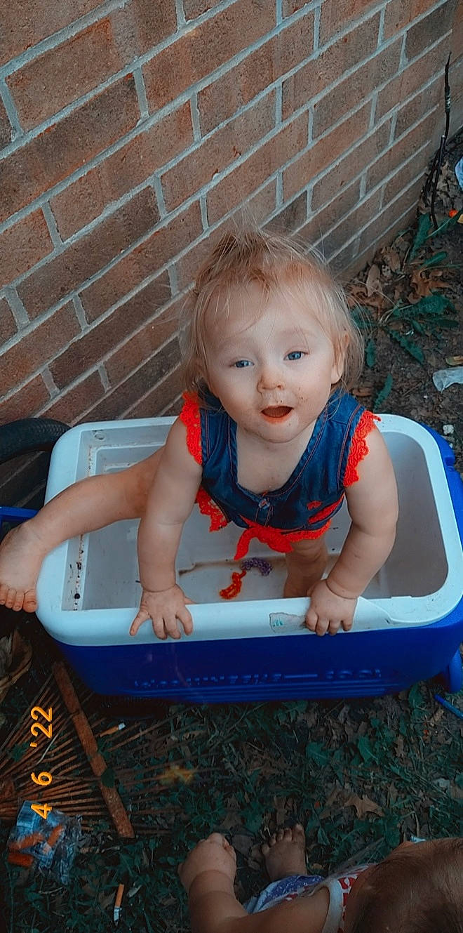 Karma is registered to the contest to win money with this photo: baby, baby_products, baby_toddler_clothing, brick, brickwork, child, electric_blue, eye, face, fun, grass, hair, happy, leisure, person, pink, play, recreation, sitting, smile