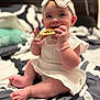 baby, bed, bedding, bow, bracelet, chewing, child, cute, foot, hand, headband, indoors, infant, pillow, sitting, skin, smiling, soft_light, tag, white_dress
