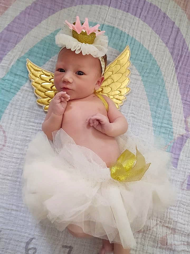 Marley is registered to the contest to win money with this photo: angel, baby, child, costume, costume_accessory, fictional_character, hair_accessory, headpiece, headwear, person, pink, supernatural_creature, toddler, wing
