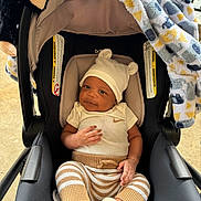 Jasiah joined the competition — help win amazing prizes! baby, car_seat, hat, blanket, plush_toy, monkey_toy, infant, baby_clothes, striped_pants, socks, cute, smiling, indoors, child, seat, comfort, portrait, young_child, cozy, soft_toy