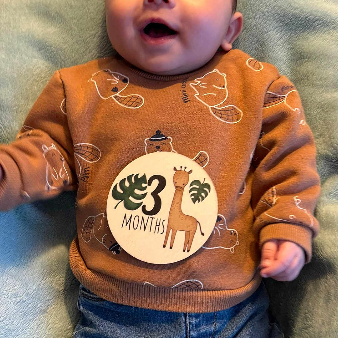 Eden a rejoint le concours — aidez-le/la à gagner de superbes lots ! baby, clothing, coat, cushion, face, furniture, happy, head, homedecor, jacket, jeans, pants, person, photography, portrait, shirt, sitting, sleeve, smile, t_shirt