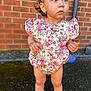 Monroe Blu joined the competition — help win amazing prizes! toddler, child, outdoor, brick_wall, floral_clothing, pink_bows, white_shoes, socks, curly_hair, earrings, bracelet, standing, expression, blue_eyes, pavement, sunlight, person, fashion, cute, portrait