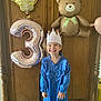 Céleste participe au concours pour gagner de l'argent avec cette photo : balloon, birthday, blue_dress, celebration, chair, child, crown, cute, festive, girl, happy, indoor, number_3, party, pigtails, smiling, standing, teddy_bear_balloon, wooden_background, young_child
