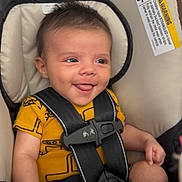 Koa is registered to the contest to win money with this photo: baby, smiling, car_seat, safety_harness, yellow_clothing, pacifier, infant, cute, child, seat_belt, indoor, happy, young_child, plush_padding, portrait, seated, secure, infant_clothing, human, closeup