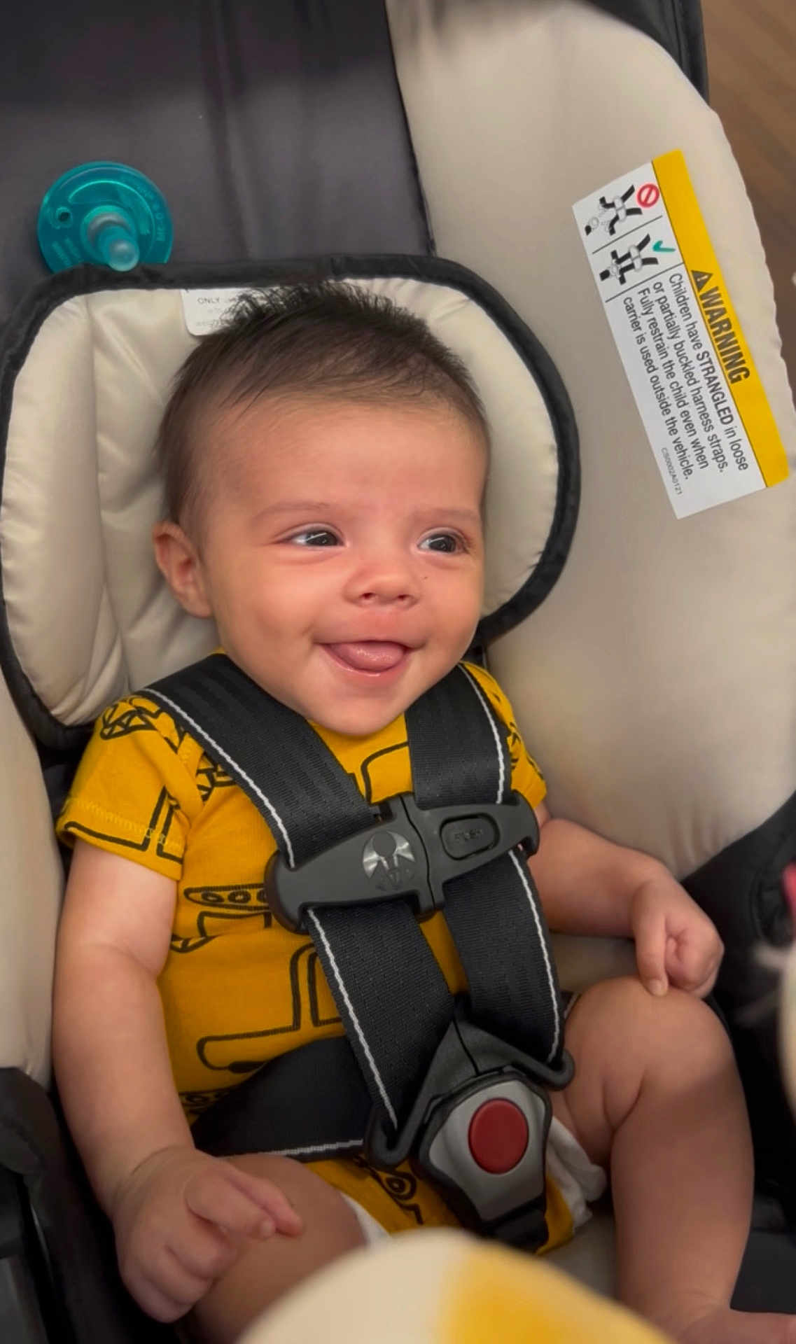 Koa is registered to the contest to win money with this photo: baby, smiling, car_seat, safety_harness, yellow_clothing, pacifier, infant, cute, child, seat_belt, indoor, happy, young_child, plush_padding, portrait, seated, secure, infant_clothing, human, closeup
