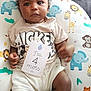 baby, infant, child, mickey_mouse, shirt, card, pillow, animal_print, elephant, giraffe, lion, tiger, monkey, couch, curly_hair, sitting, indoors, cute, portrait, expression