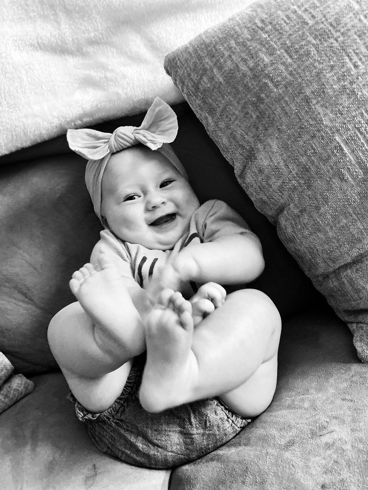 Dixie is registered to the contest to win money with this photo: arm, baby, baby_toddler_clothing, black_and_white, child, comfort, facial_expression, finger, flash_photography, grass, happy, headgear, interaction, monochrome, monochrome_photography, person, sitting, skin, smile, style