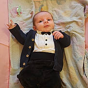 Timéo participe au concours pour gagner de l'argent avec cette photo : baby, infant, tuxedo, blanket, playpen, clothing, cute, person, child, indoors, newborn, smiling, hand, face, soft, fabric, button, black, white, pink