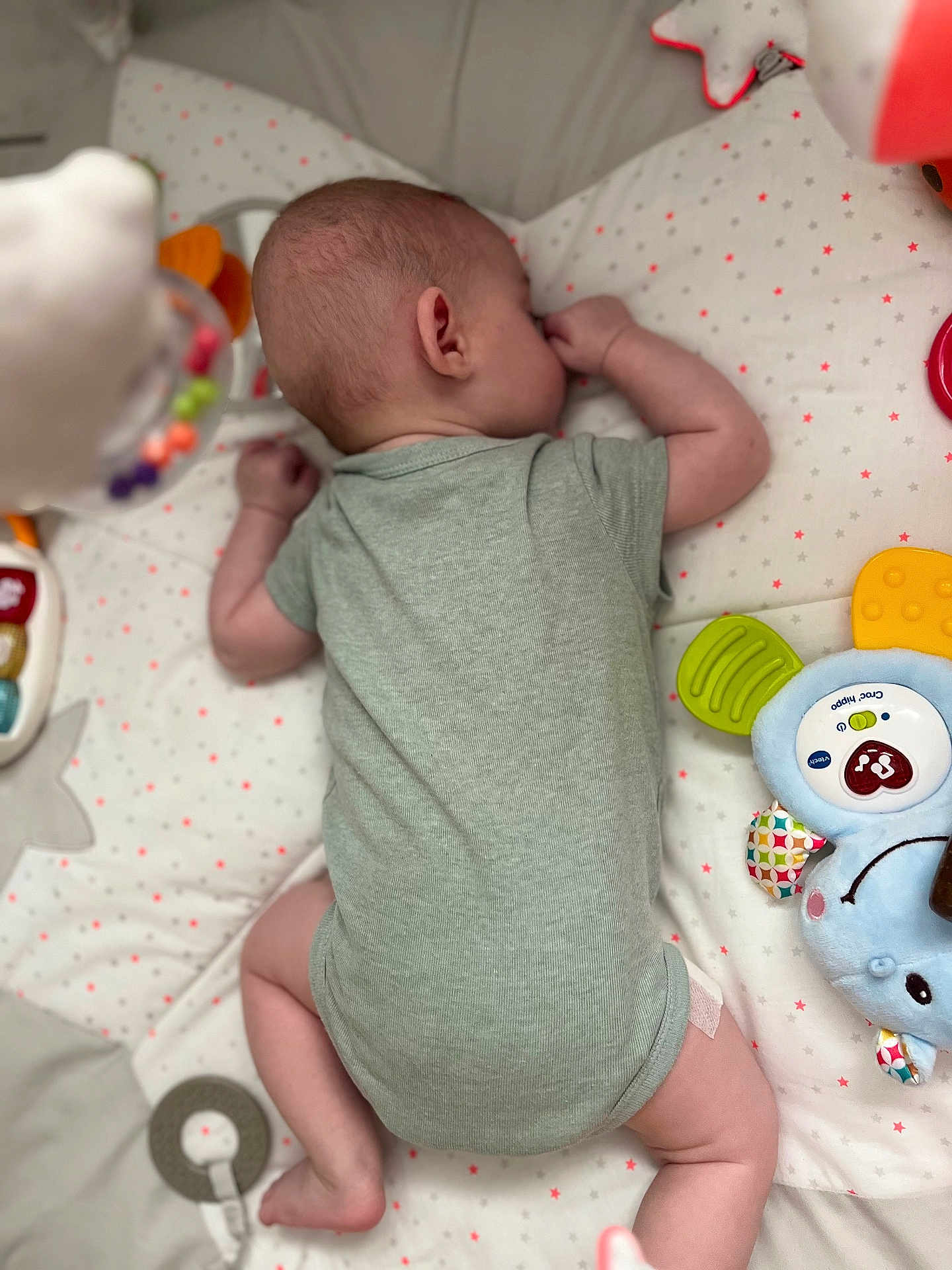Alessio participe au concours pour gagner de l'argent avec cette photo : baby, infant, onesie, playmat, toy, colorful, star_pattern, lying_down, thumb_sucking, soft_toy, child, cute, sleeping, indoors, small, peaceful, resting, plush, fabric, soft_lighting