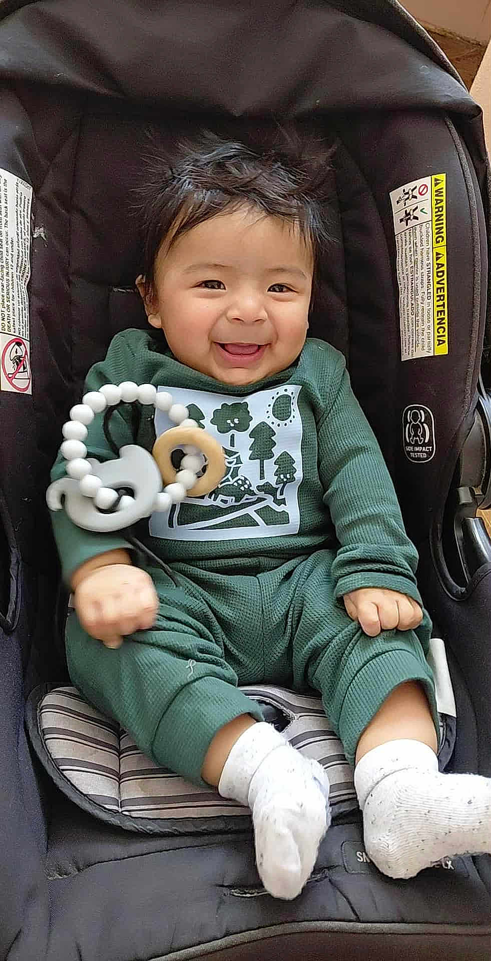 Julian joined the competition — help win amazing prizes! baby, smiling, car_seat, green_outfit, white_socks, teething_toy, pacifier, happy, child, infant, indoor, cute, person, clothing, seat, toy, hair, face, portrait, comfort