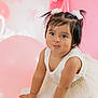 toddler, child, baby, dress, white_dress, cute, portrait, pink_background, balloons, party, celebration, hair_ties, flower_accessories, smile, happy, indoor, cute_face, bracelet, hands, posing