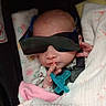 Violet-Jo is registered to the contest to win money with this photo: baby, infant, sunglasses, blanket, pacifier, hand, face, hospital, medical_center, wrapped, cute, newborn, child, portrait, indoor, sleeping, cozy, person, clothing, accessory