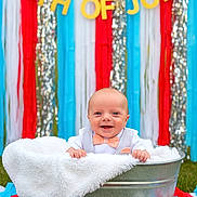 Wyatt Ford joined the competition — help win amazing prizes! baby, tub, blanket, bow_tie, grass, daisy, flower, outdoor, celebration, decoration, banner, streamers, smile, happy, person, festive, summer, holiday, cute, portrait