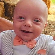 Wyatt Ford is registered to the contest to win money with this photo: baby, background, barn, bow_tie, child, clothing, cute, grass, happy, hay_bales, infant, love, outdoor, person, portrait, sitting, smile, sunlight, vest, wood