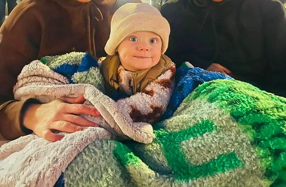 Jaylon is registered to the contest to win money with this photo: baby, cap, child, comfort, eye, fashion_accessory, fur, grass, happy, headgear, headwear, knit_cap, person, sitting, skin, smile, textile, toddler, tree, winter