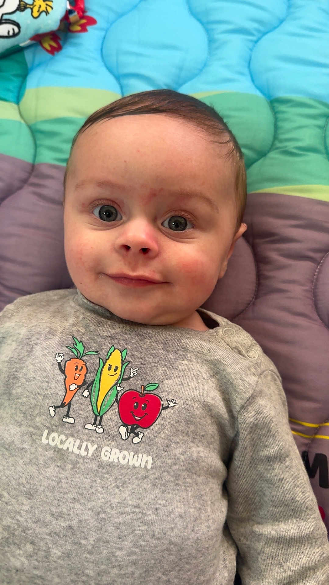 Morgan joined the competition — help win amazing prizes! baby, child, infant, onesie, locally_grown, clothing, face, eyes, smile, cheeks, hair, blanket, quilted_blanket, toy, lying_down, portrait, closeup, cute, nursery, cartoon_vegetables