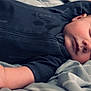 baby, sleeping, onesie, guitar_print, blanket, soft_texture, peaceful, infant, child, face, hand, fingers, bed, rest, cozy, portrait, closeup, relaxation, cute, comfort