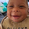 Iyla joined the competition — help win amazing prizes! adorable, baby, bedroom, bib, blanket, brown_clothing, child, close_up, eyes, face, happy, indoor, infant, mouth, nose, photography, portrait, smiling, striped_clothing, toy