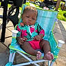 baby, backyard, chair, child, colorful_clothing, concrete, cute, expression, grass, infant, leisure, outdoor, party_decorations, portrait, relaxed, seat, summer, sunlight, toddler, vacation
