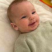 Maël a rejoint le concours — aidez-le/la à gagner de superbes lots ! adorable, baby, bed, blanket, cheek, closeup, cute, eyes, face, happy, infant, knit_sweater, laying, mouth, newborn, pillow, portrait, skin, smiling, soft_lighting