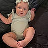 Paisley is registered to the contest to win money with this photo: baby, infant, headband, onesie, couch, leather, sitting, cute, child, portrait, indoors, soft_lighting, smile, blue_eyes, curious, small_hands, legs_crossed, comfortable, relaxed, home