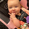 baby, infant, child, stroller, pink, black, seatbelt, hand, fingers, curious, clothing, flamingo, pattern, shopping_cart, cute, portrait, indoor, seat, face, expression