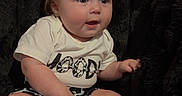 Ellie joined the competition — help win amazing prizes! baby, barefoot, black_background, blanket, blonde_hair, blue_eyes, chair, child, cute, fluffy, graphic_shirt, indoors, photography, ponytails, portrait, shorts, sitting, smiling, toddler, wide_eyed