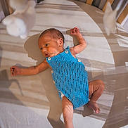 Léo participe au concours pour gagner de l'argent avec cette photo : baby, newborn, crib, blue_romper, sleepwear, infant, sleeping_area, wooden_crib, soft_lighting, shadow, peaceful, indoors, cute, small, lying_down, child, portrait, baby_clothes, resting, newborn_baby