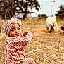 Siyanna participe au concours pour gagner de l'argent avec cette photo : child, toddler, polka_dot, pink_clothing, headwrap, flowers, wire_fence, outdoor, grass, tree, animal, goat, nature, baby, smiling, curious, countryside, daylight, portrait, sitting